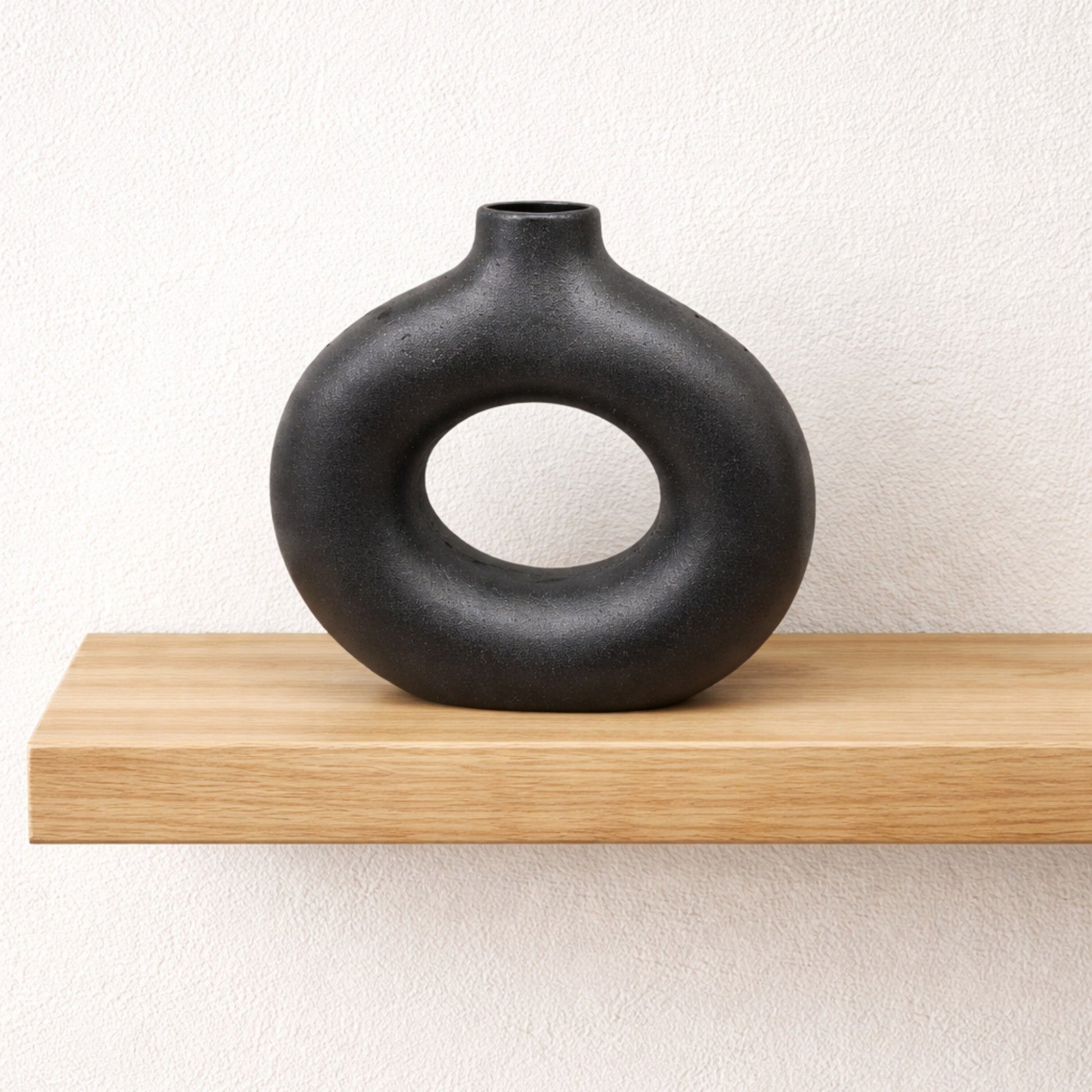 Black ceramic Frankly Cotton Sculptural Donut Vase by Nest & Stem Homewares, featuring a modern, donut-shaped design.