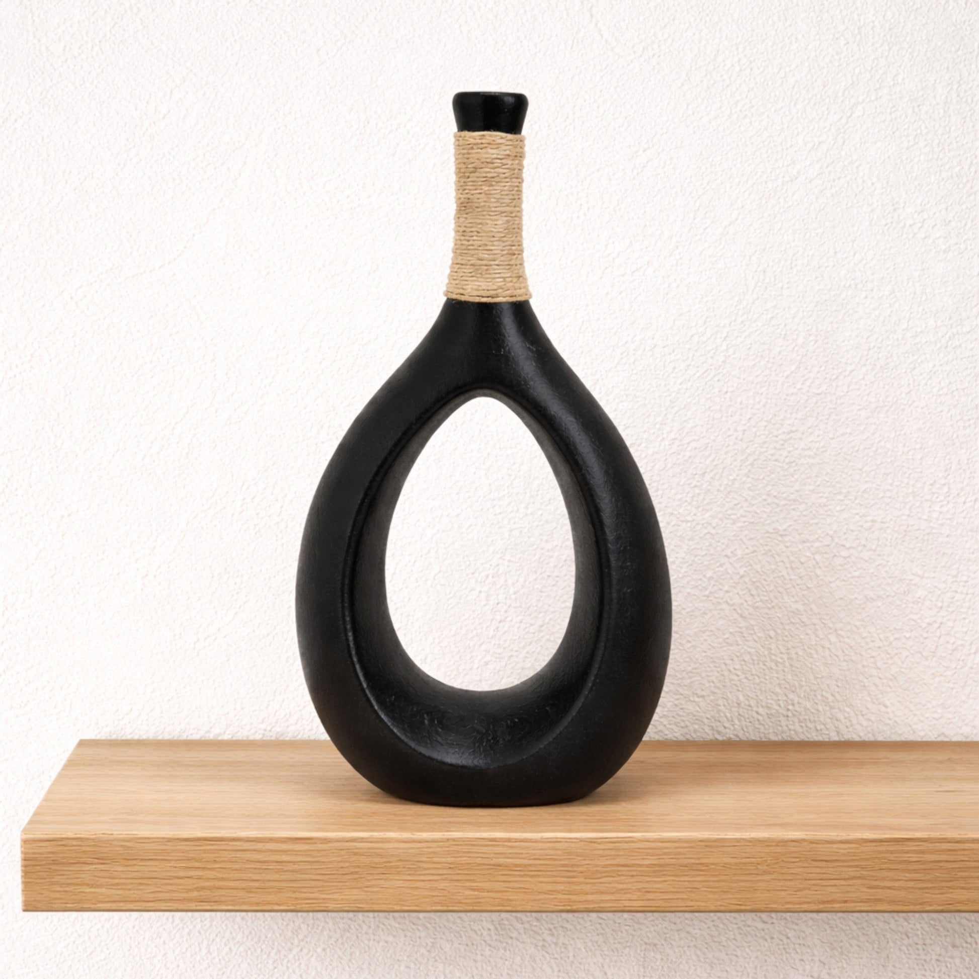 Black ceramic teardrop sculptural vase with smooth curves, designed by Nest & Stem Homewares for modern home decor.