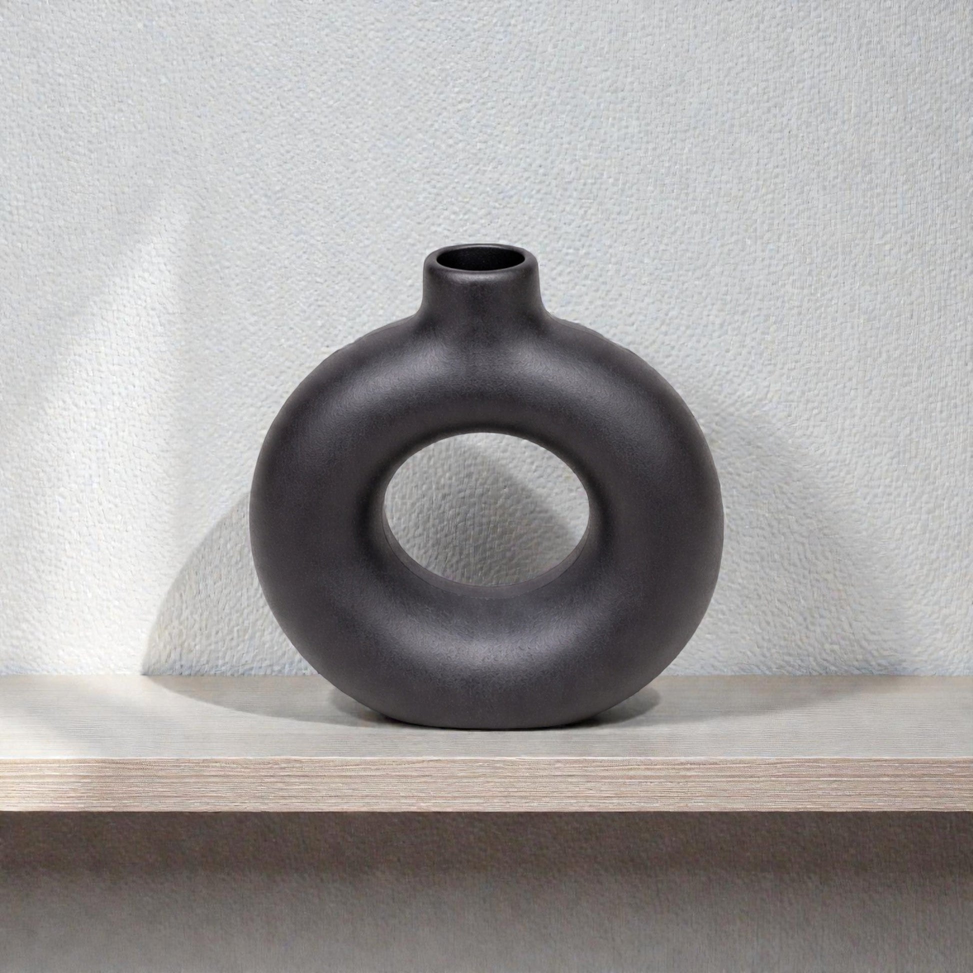 Black ceramic sculptural ring vase by Nest & Stem Homewares, featuring a modern, artistic design perfect for contemporary decor.