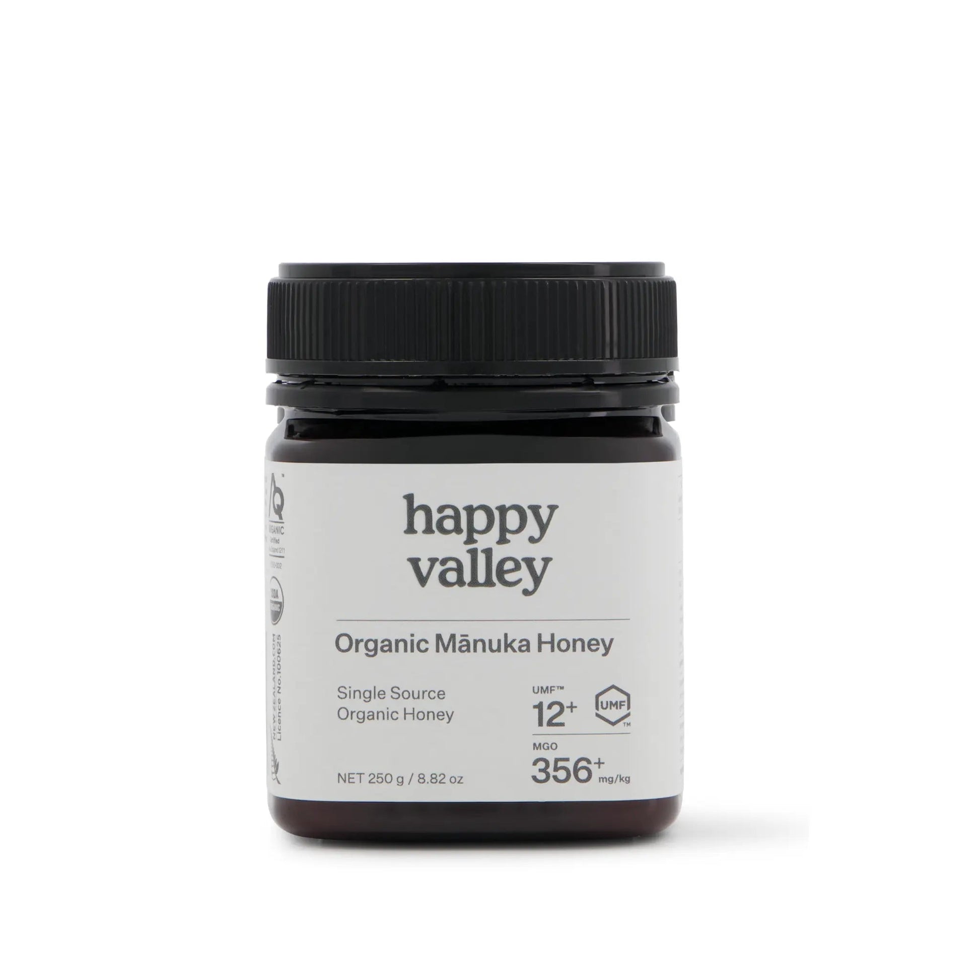 Organic Manuka Honey UMF® 12+ jar from Happy Valley Honey, showcasing golden, thick honey with a white label and wooden honey dipper
