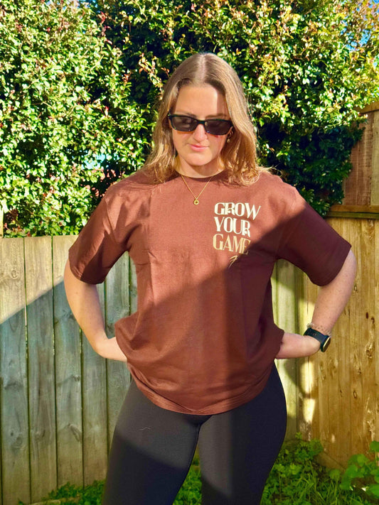 Unisex oversized coffee-colored T-shirt by Fuaark Nz, made for ultimate comfort, shown on a model with casual styling.