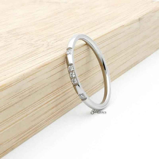 Silver stainless steel ring with five CZ inlays, crafted by Glitters, showcasing a sleek band design.