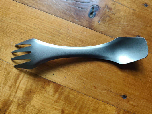 Titanium 3-in-1 camping utensil from Mead's Supply, ultralight spork with knife edge, ideal for camping equipment.
