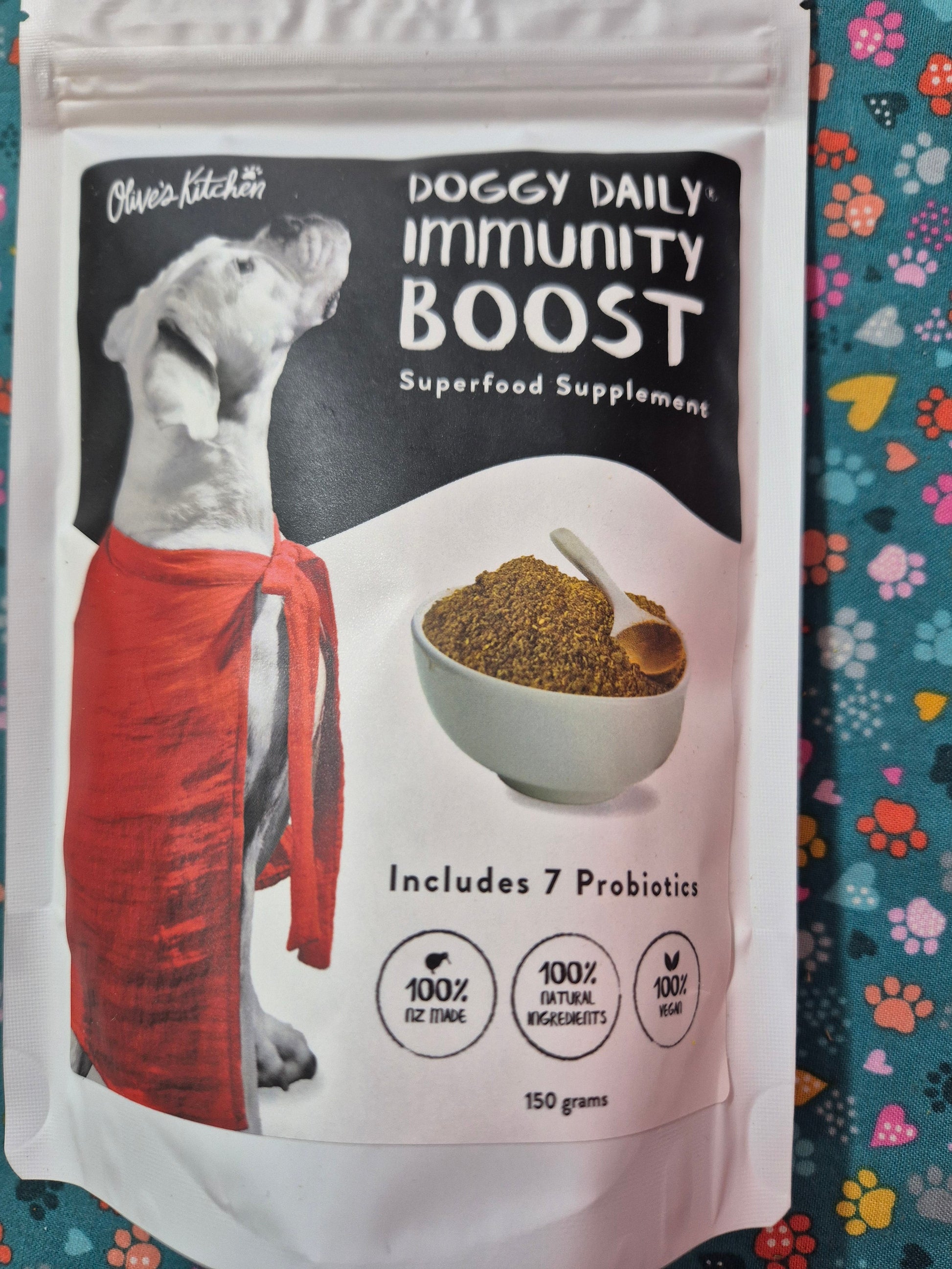 Doggy Daily Immunity Boost Supplement by Animal Addiction Limited in a 150g container, showing the supplement powder inside.