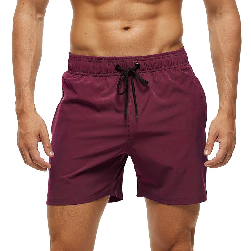 Men's Datifer Summer 2026 gym shorts with solid color design, mesh liner, zipper pockets, quick-dry fabric, ideal for beach and swim.