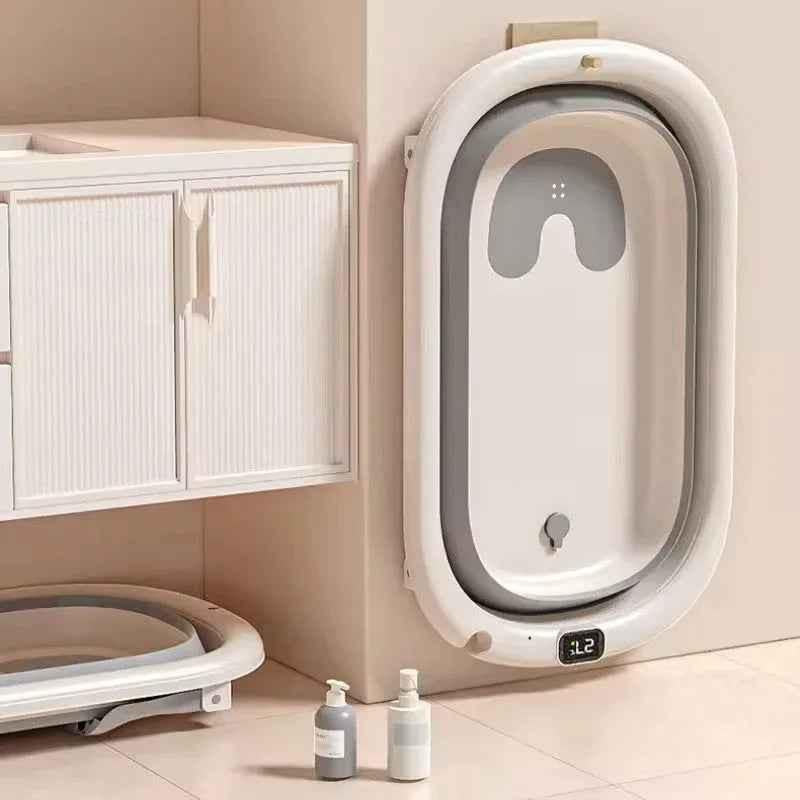 Gray foldable baby bathtub with digital thermometer and newborn support rack, designed for safe, comfortable bathing.
