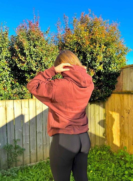 Unisex brown oversized hoodie by Fuaark Nz, shown on a model, featuring a relaxed fit and comfortable style.