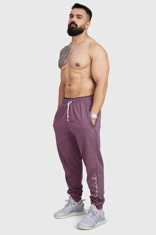 Fuaark Nz mauve oversized joggers made of soft, comfortable fabric, laid flat showing relaxed fit and stylish design.