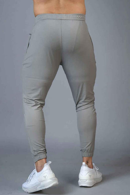 Light grey nylon joggers from Fuaark Nz with a relaxed fit, featuring an elastic waistband and side pockets.