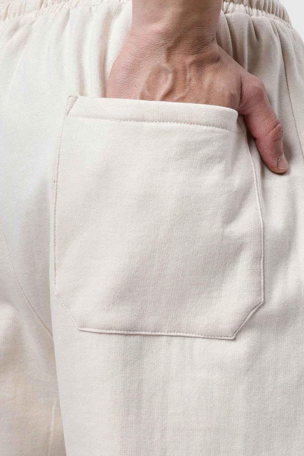 Beige Fuaark NZ laidback relaxed joggers pants with a comfortable fit, shown on a model in a casual indoor setting.