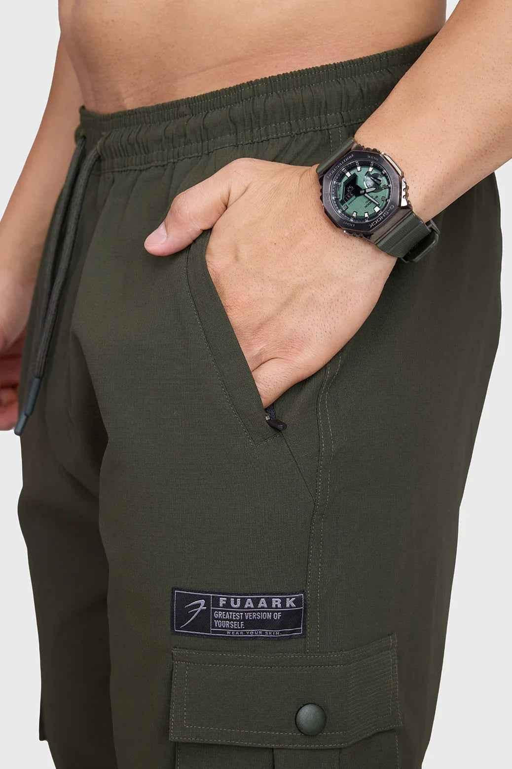 Fuaark Nz army script cargo joggers in olive green with multiple pockets and relaxed fit, casual streetwear style.