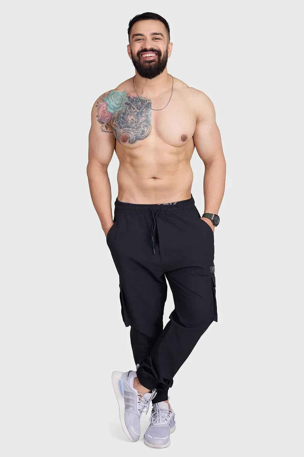 Black Fuaark Nz Script Cargo Joggers with multiple pockets and relaxed fit, displayed on a model.