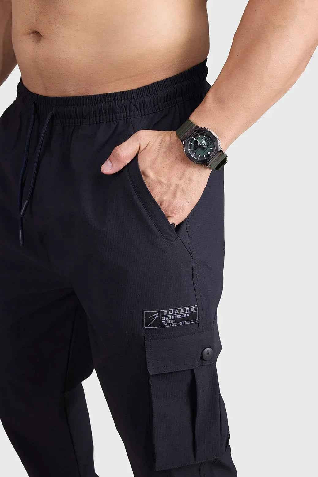 Black Script Cargo Joggers by Fuaark Nz, featuring a relaxed fit with multiple cargo pockets and comfortable elastic cuffs.