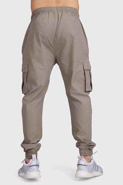 Brown Fuaark Nz Script Cargo Joggers with multiple pockets and relaxed fit, styled on a model.