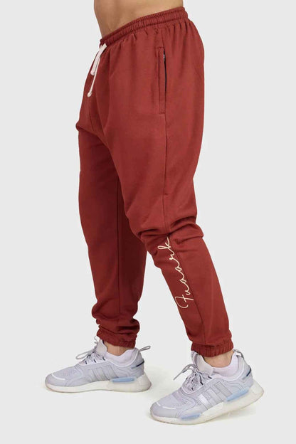 Rust-colored Signature Oversized Band Joggers by Fuaark Nz, showing relaxed fit and stylish design details.