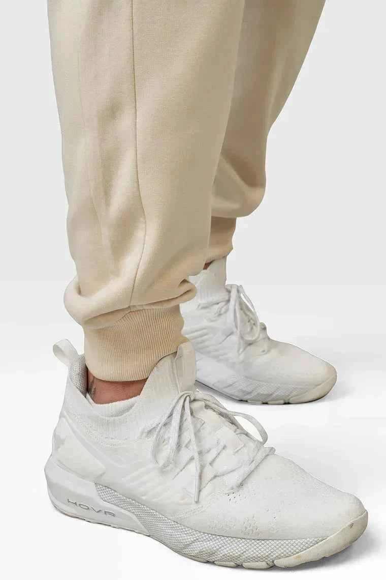 Beige oversized joggers from Fuaark Nz with relaxed fit and drawstring waist, casual athletic style.