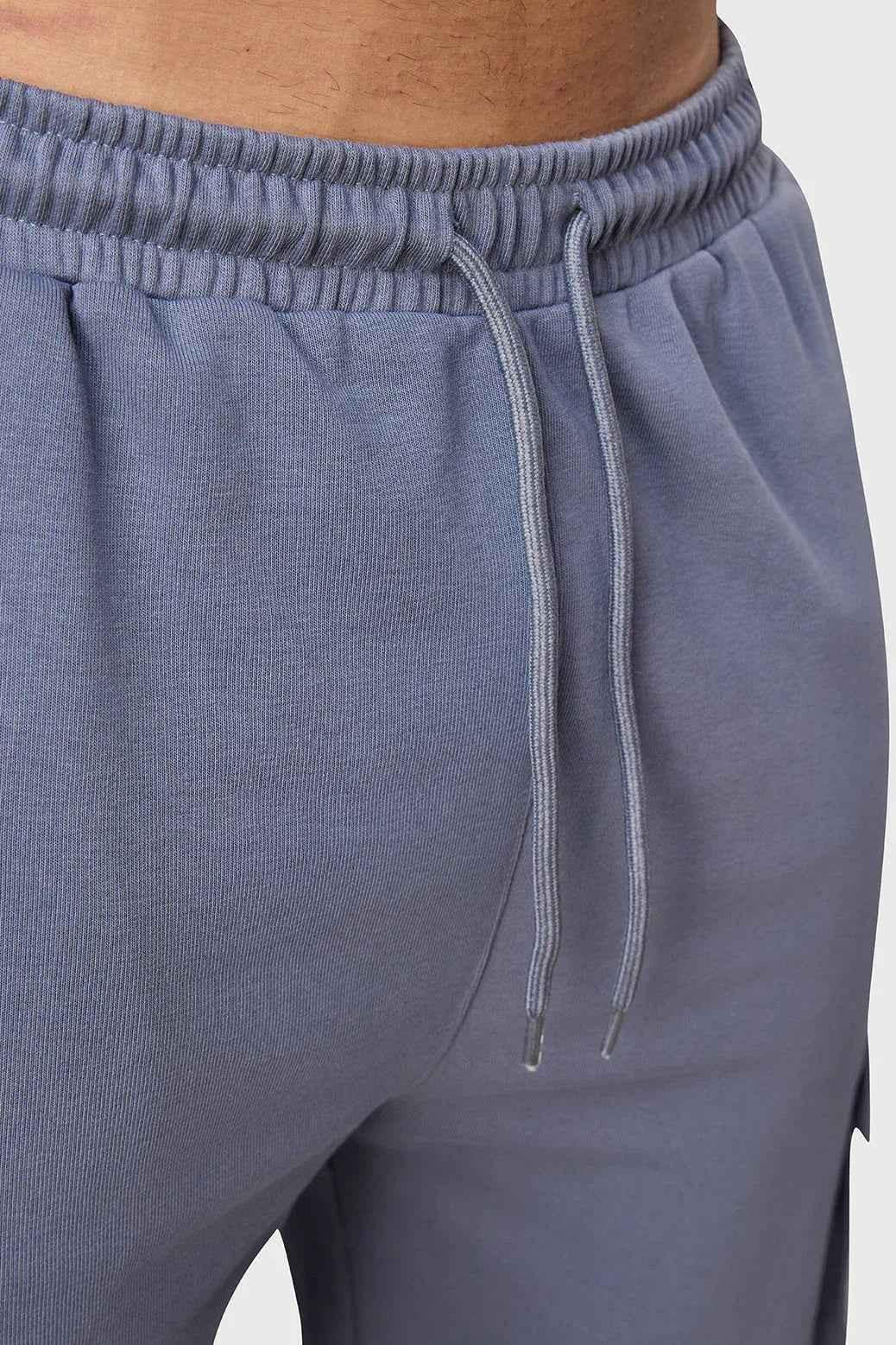 Grey Fuaark Nz Pinnacle Pocket Pants joggers with side pockets and elastic waistband, shown on a model.