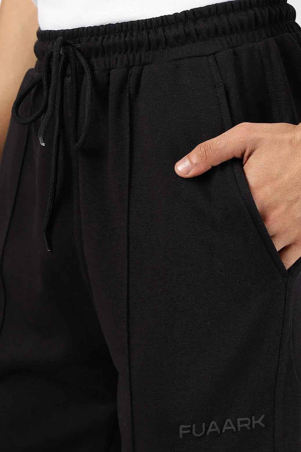 Fuaark Nz Pinnacle black straight leg pants with oversized fit and 2-way stretch, displayed on a hanger.