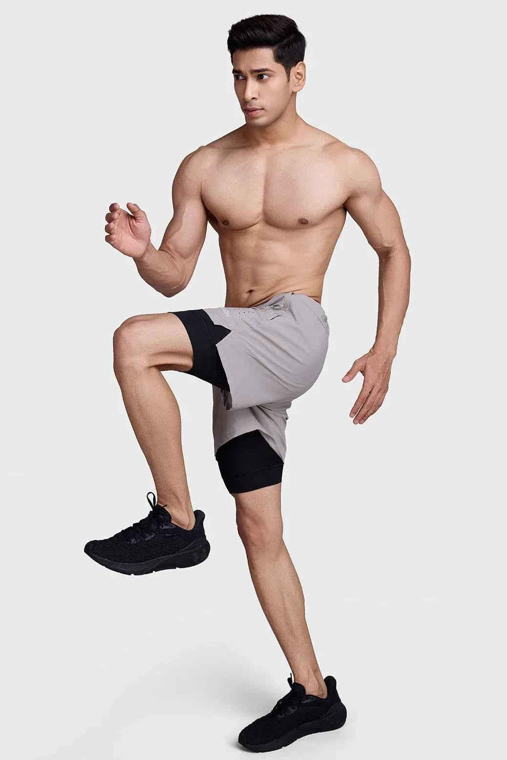 Beige 2-in-1 laser shorts with black accents by Fuaark NZ, featuring a stylish, fitted design for active wear.