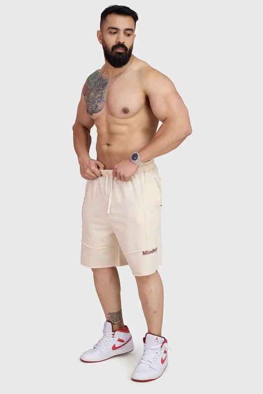 Beige raw edge oversized shorts from Fuaark Nz, casual fit with distressed hem, shown on model.