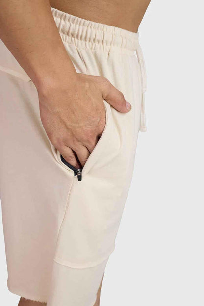 Beige raw edge oversized shorts by Fuaark Nz, casual fit with frayed hem, lightweight fabric, and relaxed style.