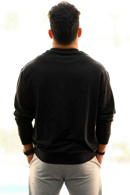 Black oversized sweatshirt from Fuaark Nz, showcasing a cozy, relaxed fit perfect for effortless style and comfort.