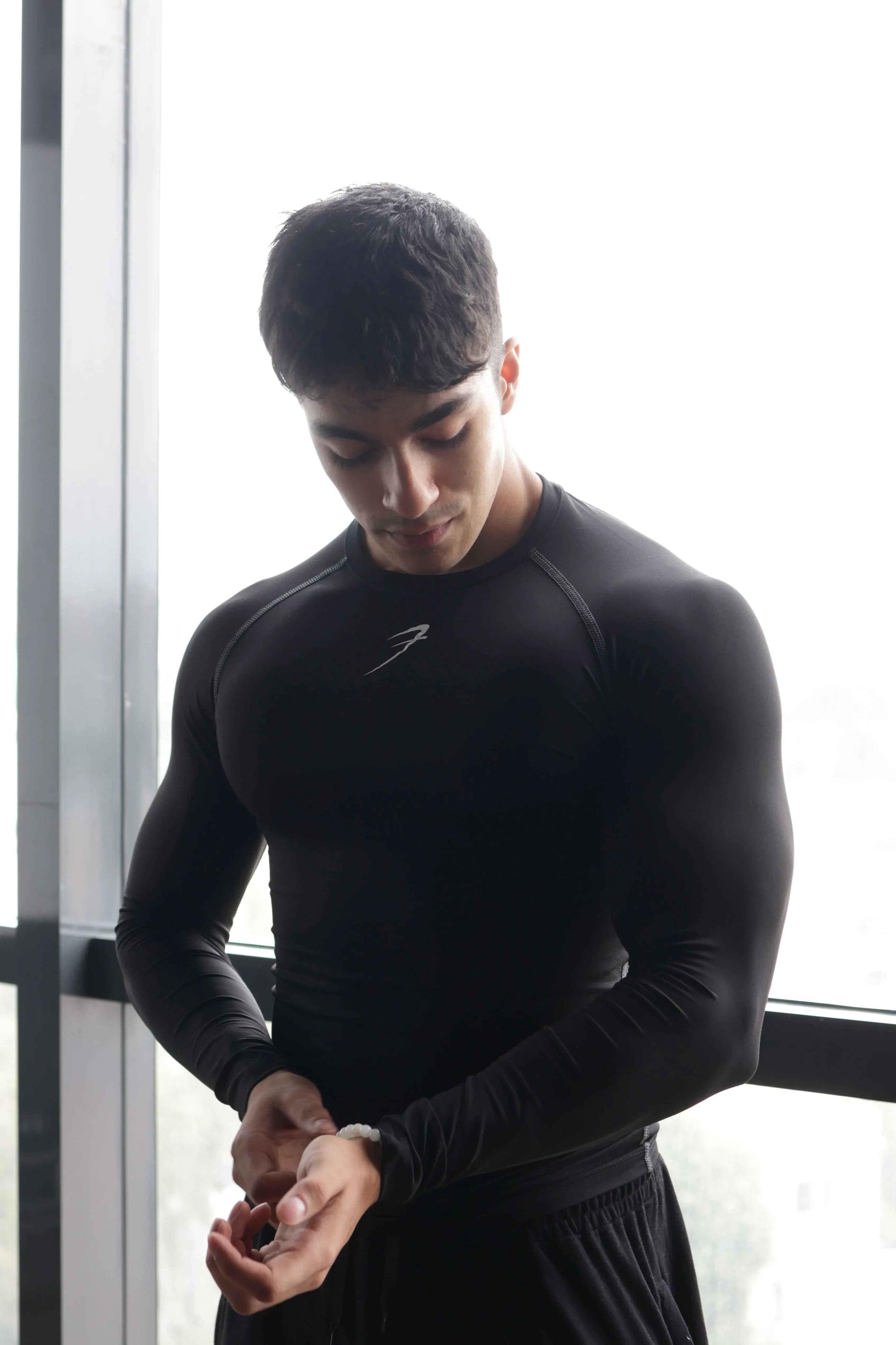 Black compression full-sleeve T-shirt by Fuaark Nz, showcasing a fitted design and breathable fabric for athletic wear.
