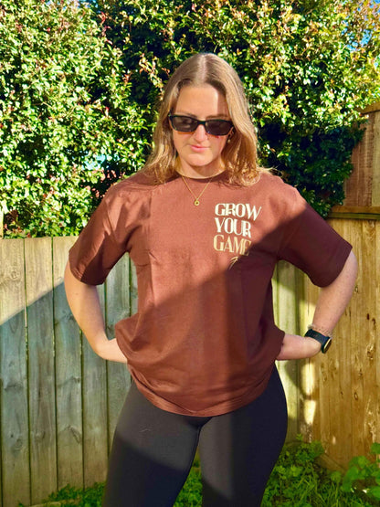 Unisex oversized coffee-colored T-shirt by Fuaark Nz, made for ultimate comfort, shown on a model with casual styling.