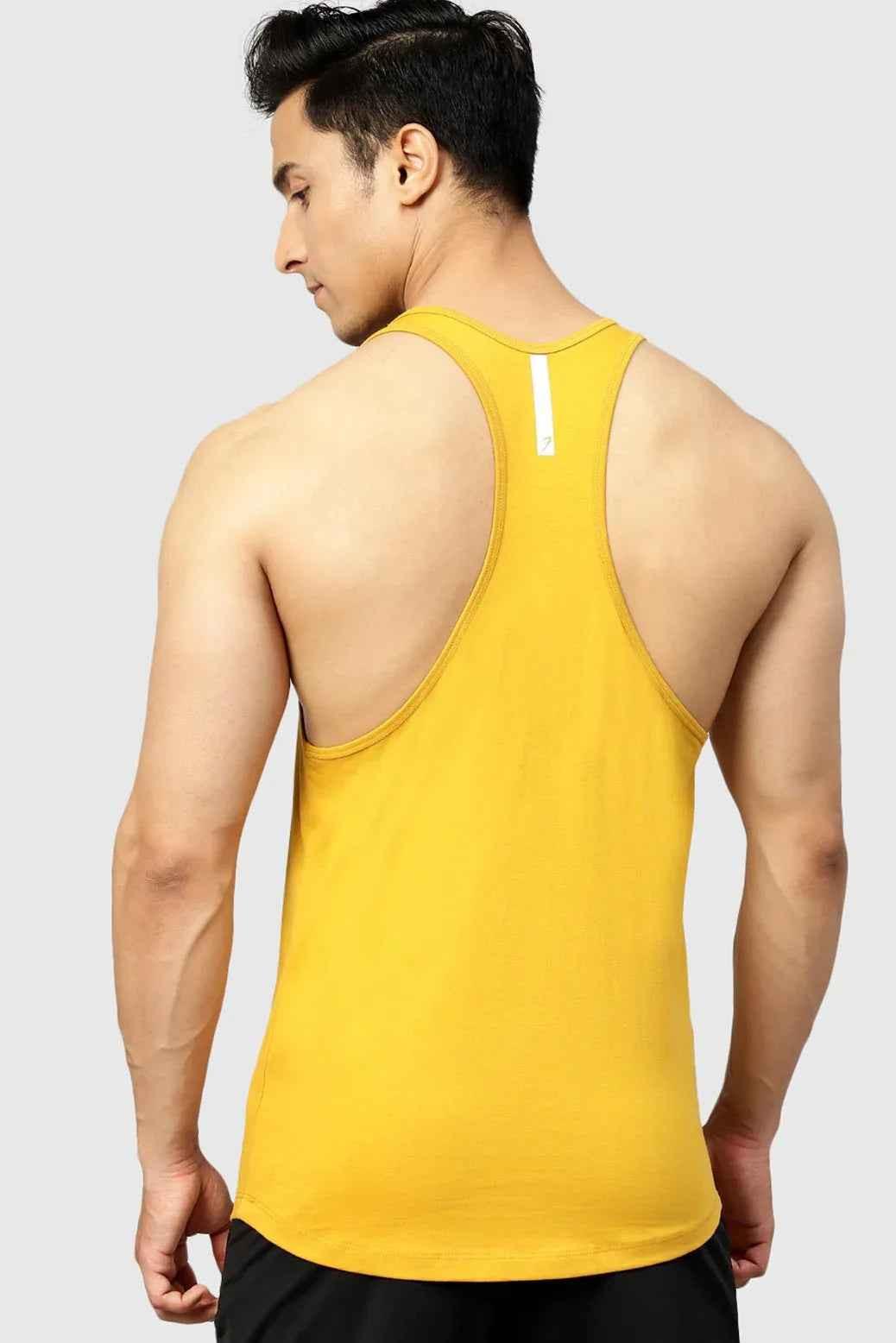 Fuaark Nz Legacy Stringer Mustard tank top shown on a hanger, featuring a vibrant mustard color and sleeveless design.