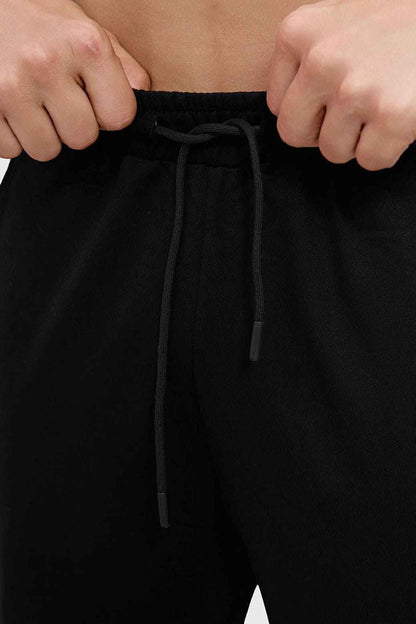 Black Phantom Straight Tracks Track Pants by Fuaark NZ, showcasing a sleek, fitted design with elastic waistband and side pockets.