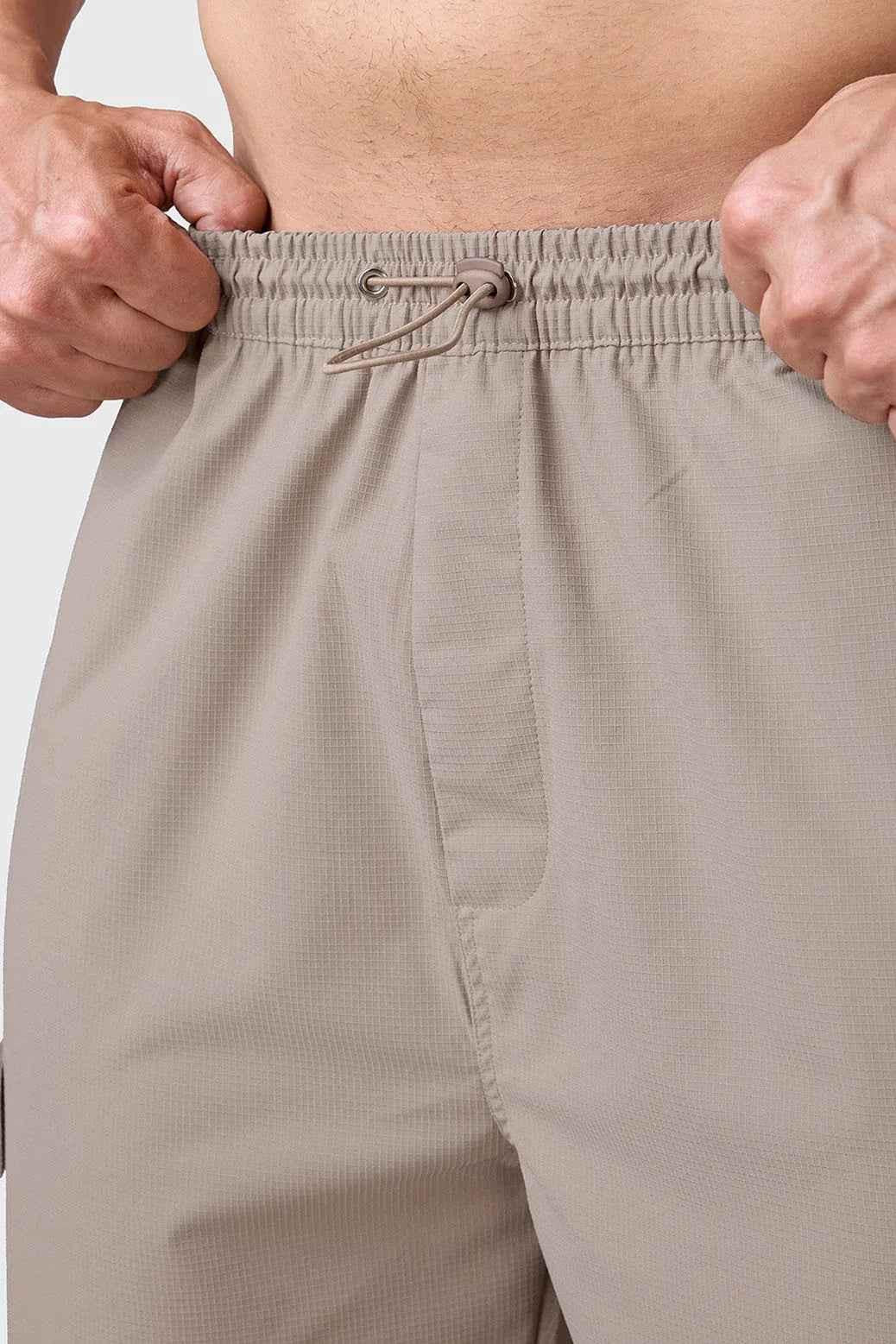 Beige Fuaark Nz carpenter cargo pants in a relaxed track style with multiple pockets and sturdy fabric.