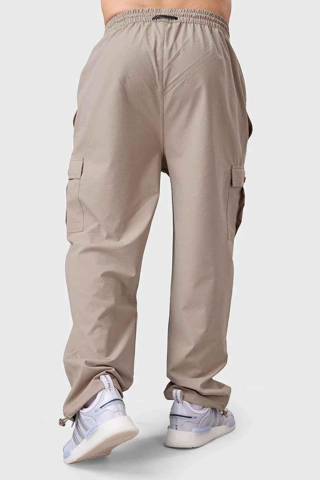 Beige Fuaark NZ carpenter cargo track pants with multiple pockets and relaxed fit, suitable for work or casual wear.