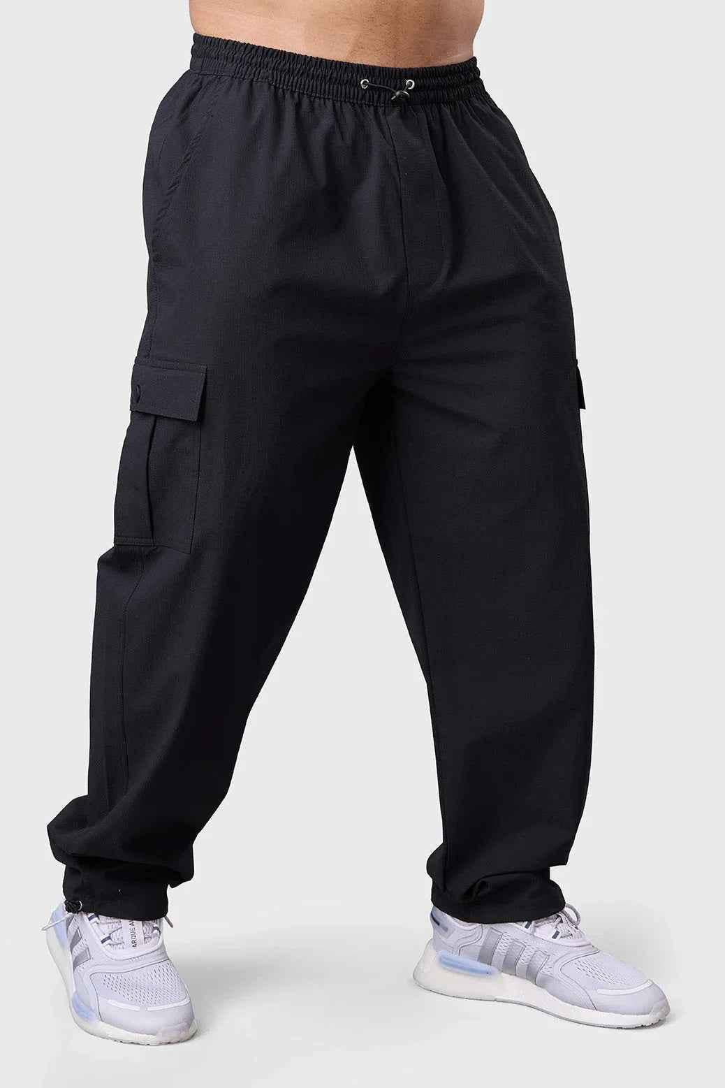 Black Fuaark NZ carpenter cargo track pants shown, featuring multiple pockets and durable fabric for work or casual wear.