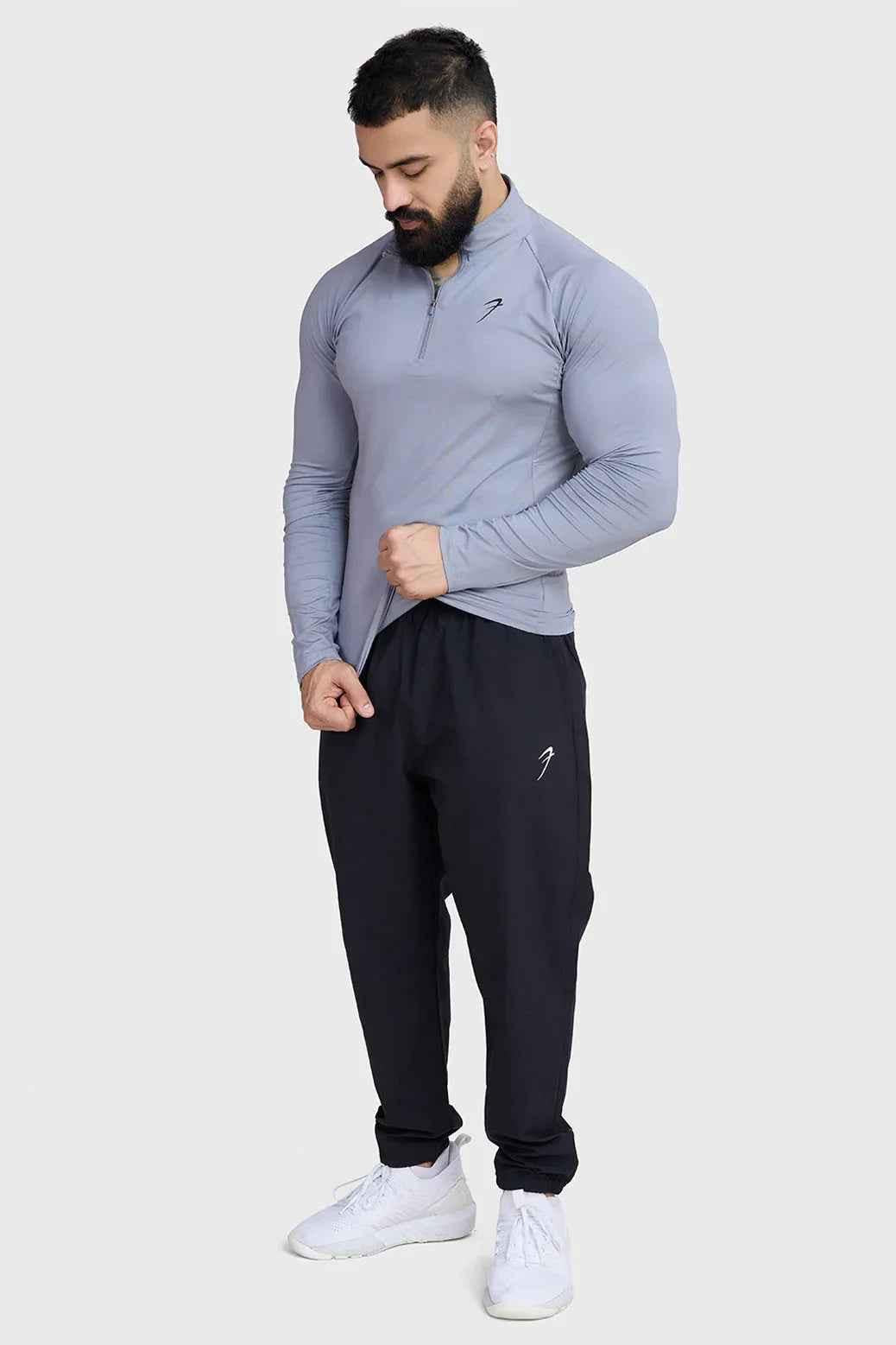 Fuaark Nz black track joggers, essential athletic pants with a comfortable fit and modern style, shown on a model.