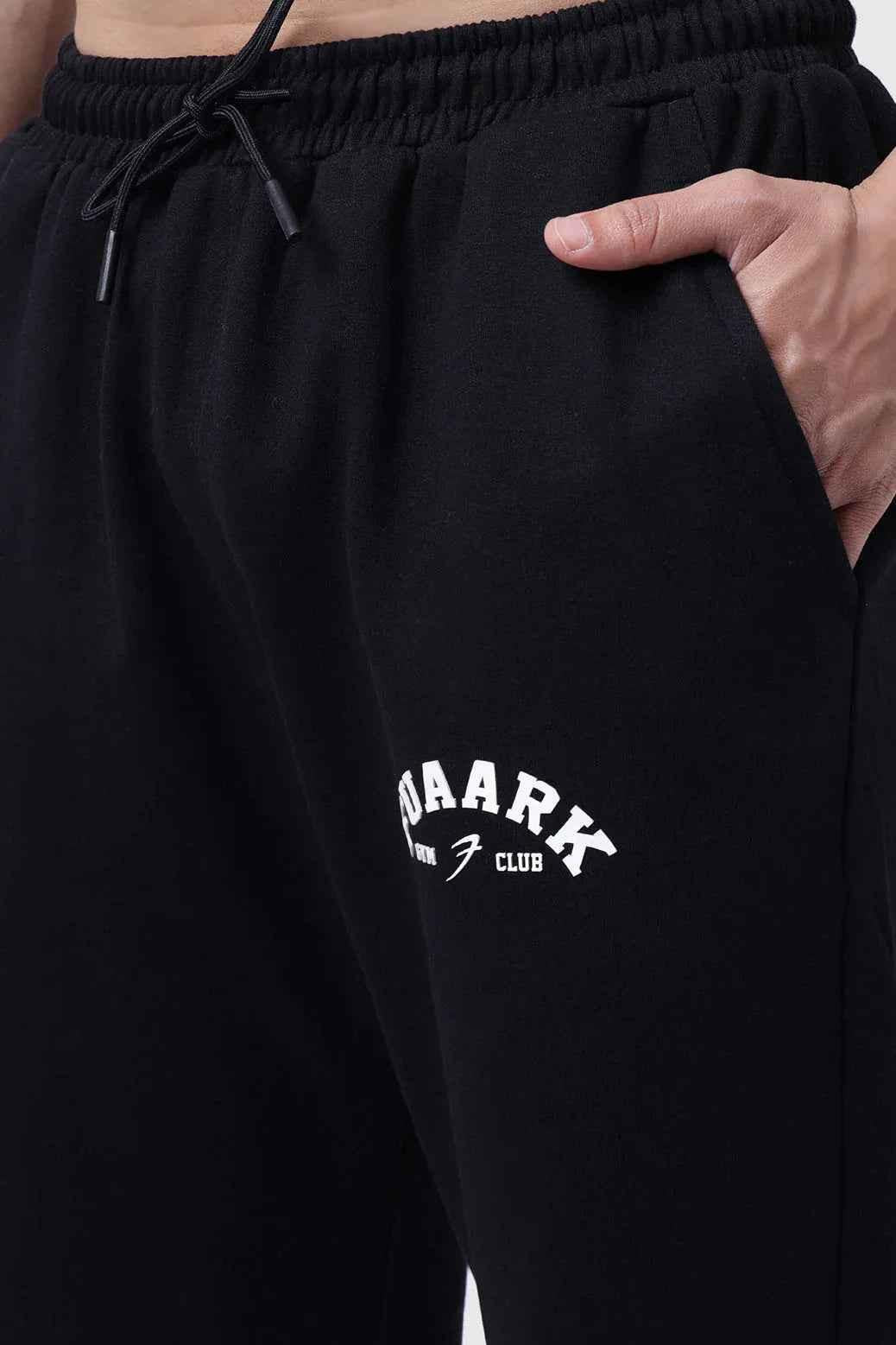 Fuaark Nz black relaxed fit track pants, laidback style, designed for comfort, with an elastic waistband and tapered legs.