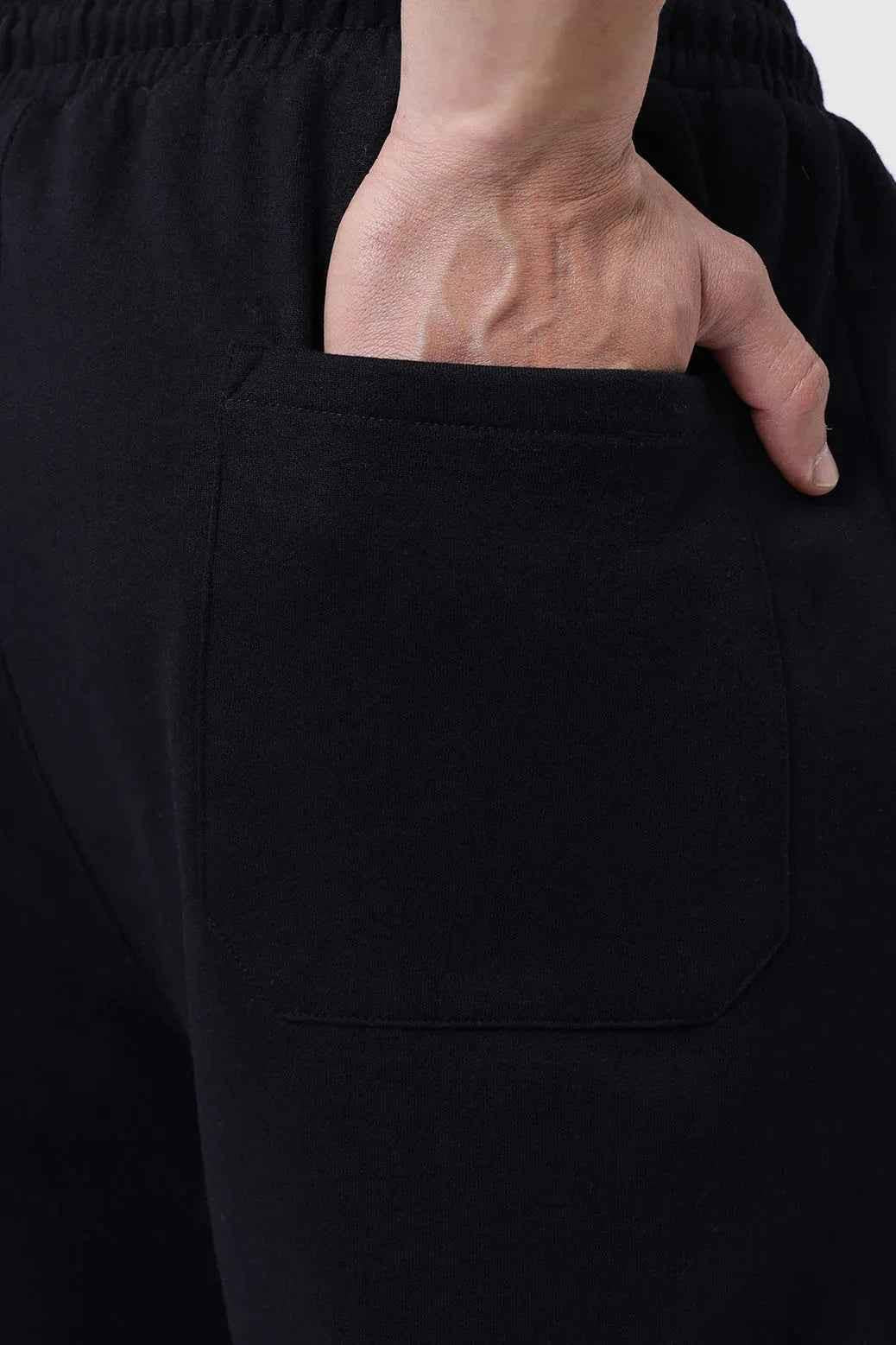 Fuaark Nz black relaxed fit track pants with a laidback style, featuring a comfortable waistband and tapered legs for casual wear.