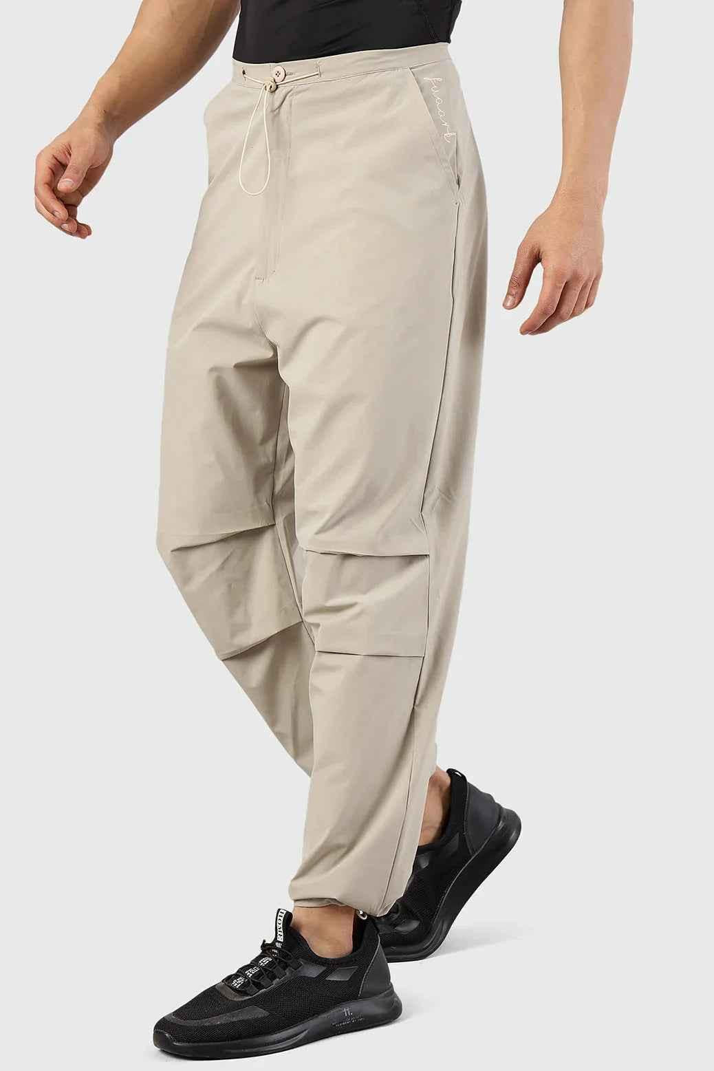 Beige Sublime Parachute Pants by Fuaark Nz, stylish track pants with a relaxed fit and modern design.