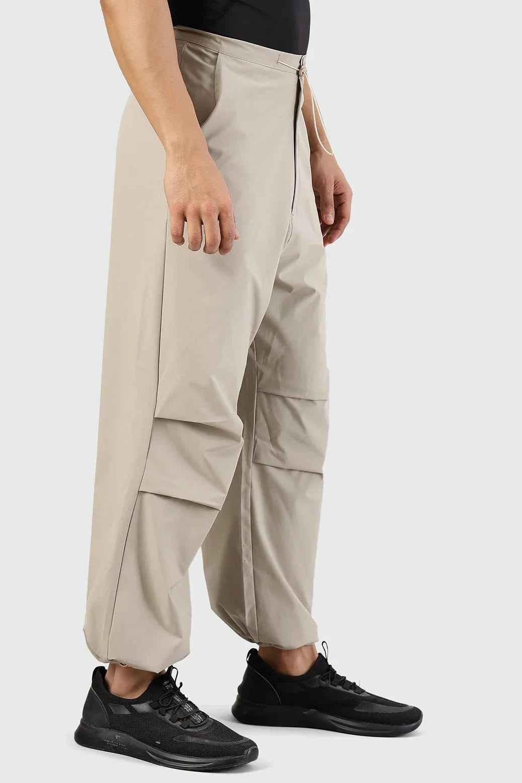 Beige Fuaark Nz Sublime Parachute Pants track pants with relaxed fit and adjustable waistband, shown on a model.