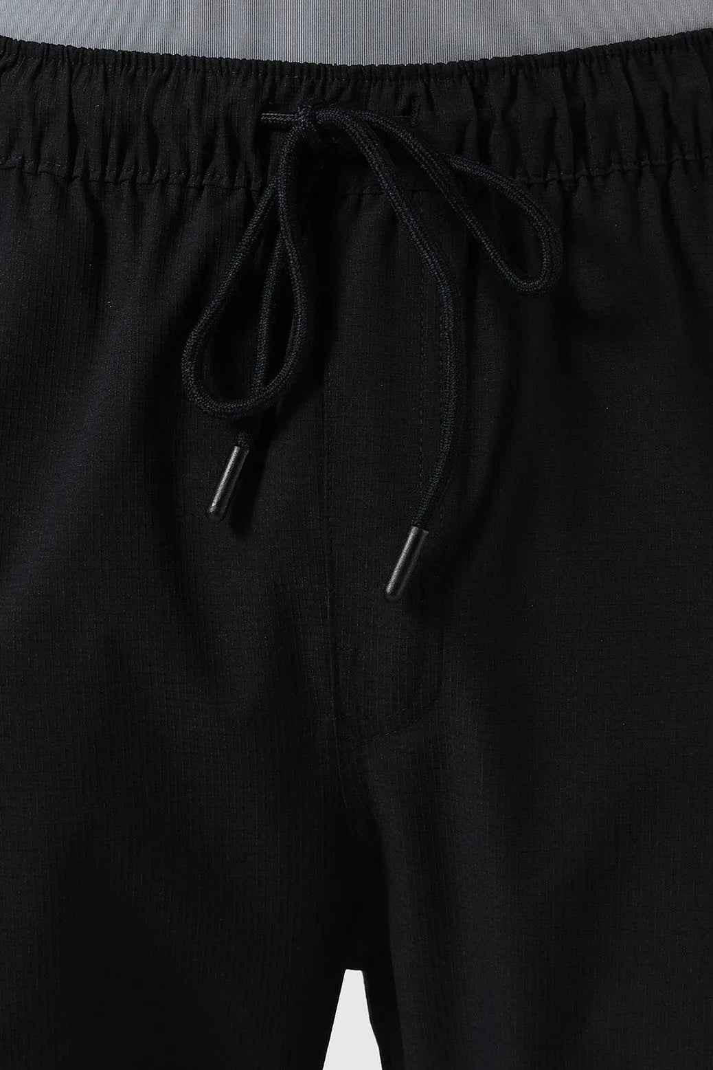 Fuaark Nz Vitality Straight Black Track Pants laid flat, showing their sleek design and comfortable fit for active wear.