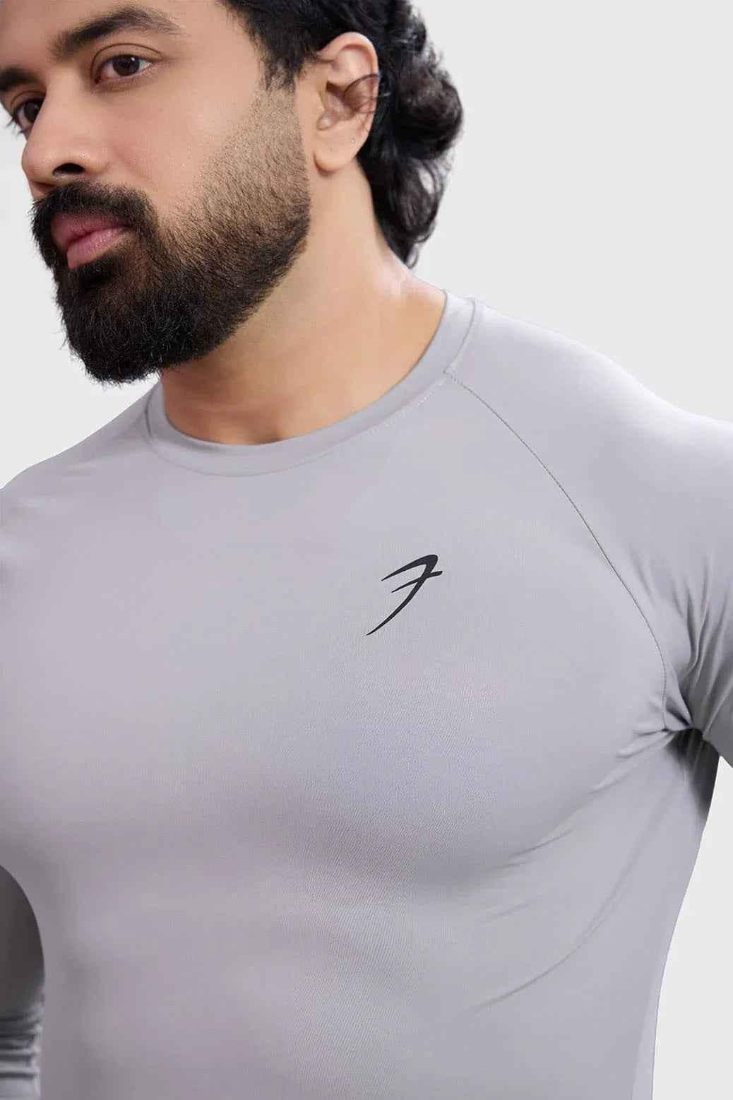 Light grey Bare Nylon full-sleeves T-shirt by Fuaark Nz, shown laid flat with sleeves extended and fabric detail visible.