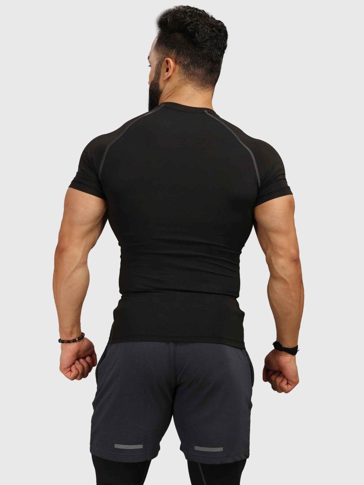 Black compression T-shirt by Fuaark Nz, close-up of fitted athletic shirt showing lightweight, stretchy fabric and sleek design.