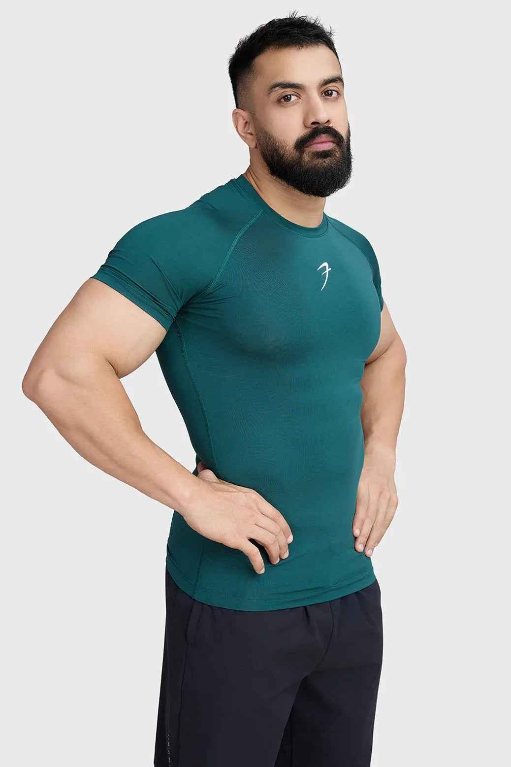 Fuaark NZ emerald green compression T-shirt displayed flat, showcasing its fitted design and smooth fabric.