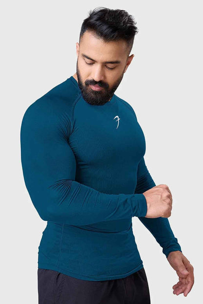 Men's teal compression long sleeve shirt by Fuaark Nz, breathable and quick-dry gym top, shown on a model.