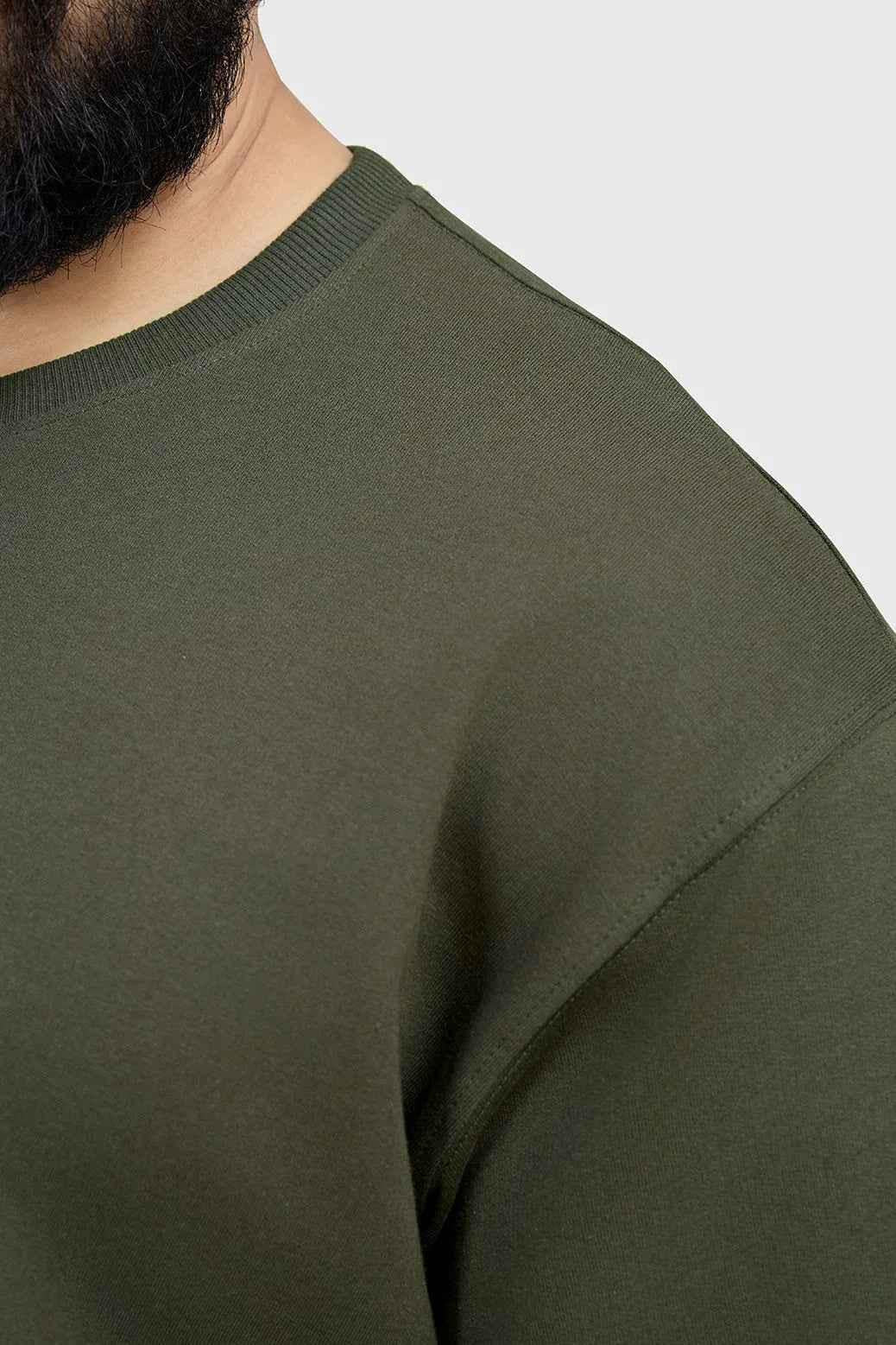 Oversized olive T-shirt from Fuaark Nz, casual fit, soft fabric, displayed on a hanger with a neutral background.
