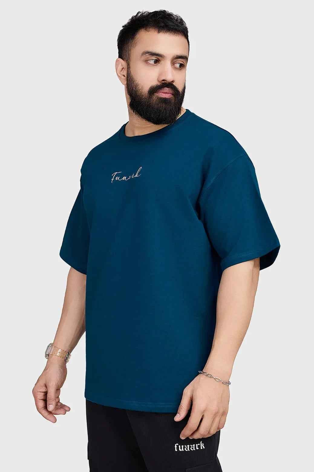 Fuaark Nz bold teal oversized T-shirt with relaxed fit, made from soft fabric, displayed on a plain background.