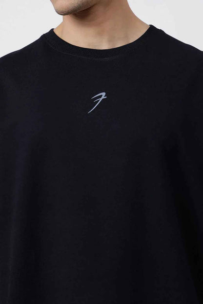 Black Fortitude Oversized T-shirt by Fuaark Nz, shown on a model, featuring a relaxed fit and casual style.