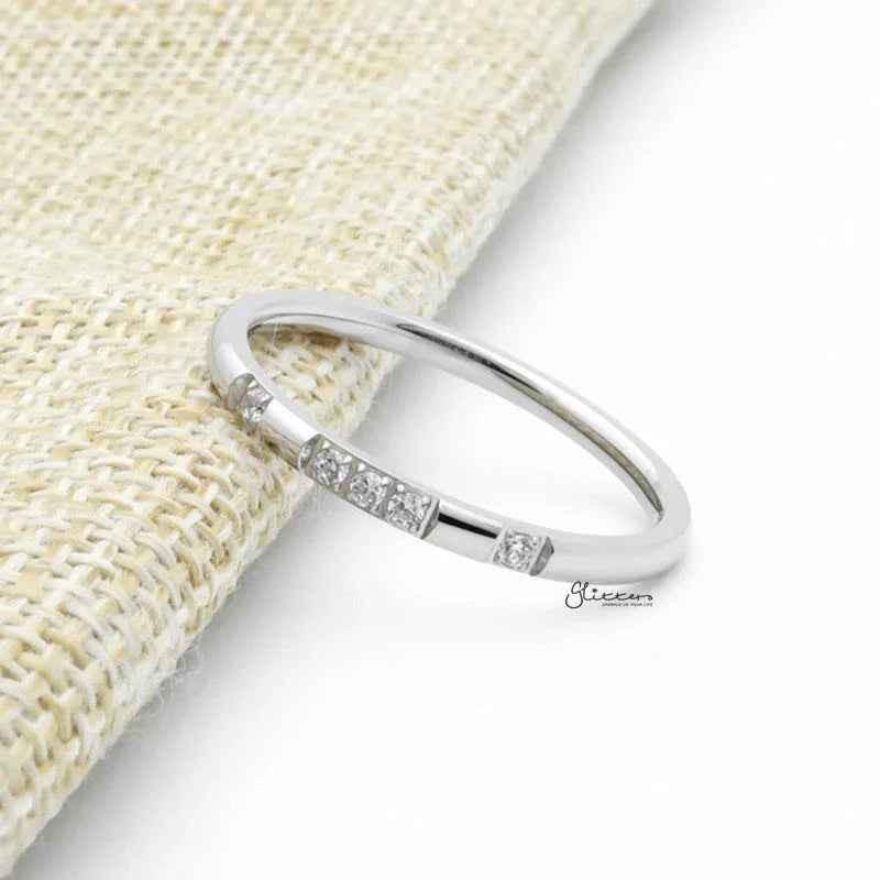 Silver stainless steel band ring with five CZ inlays, featuring a sleek design and polished finish by Glitters.