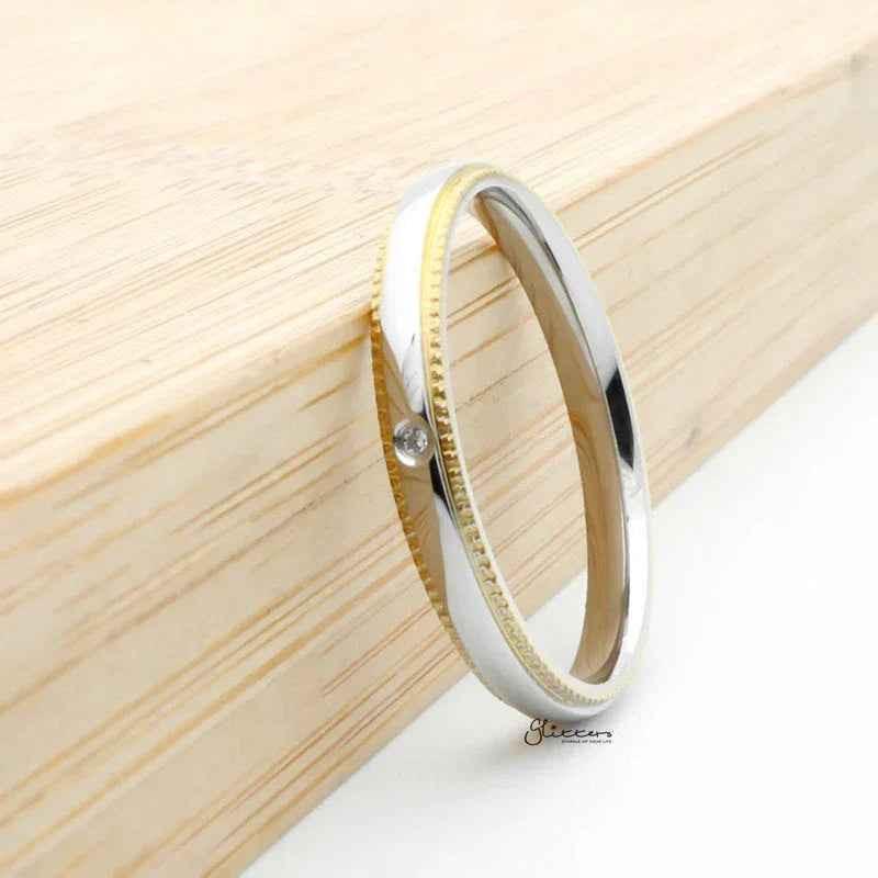 Gold stainless steel band ring with cubic zirconia inlay, stylish and durable jewelry from Glitters.