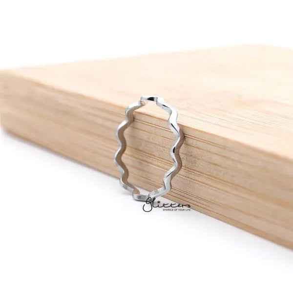 Silver stainless steel wavy women's ring from Glitters, showcasing a sleek, shiny design with a modern, elegant wave pattern.