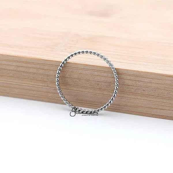Silver twisted stainless steel women's ring by Glitters, showcasing a sleek, modern design with a polished finish.